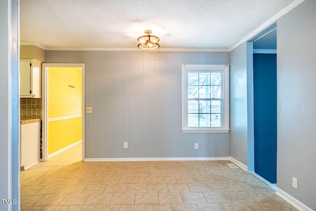 empty room with crown molding and a textured ceiling