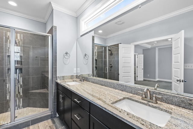 full bath with double vanity, a stall shower, crown molding, and a sink