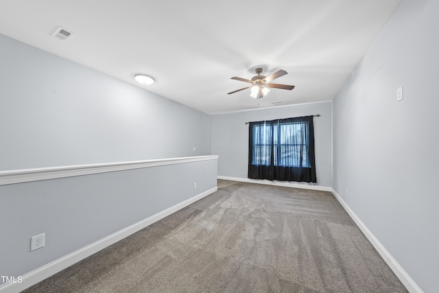 carpeted spare room with visible vents, ceiling fan, and baseboards