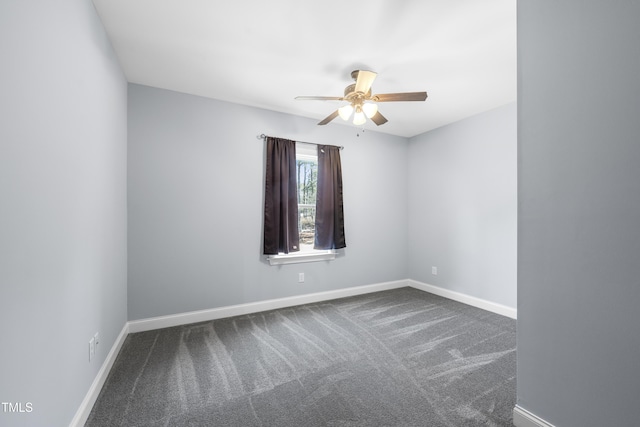 spare room with dark carpet, baseboards, and ceiling fan