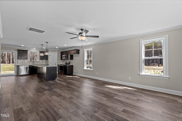 unfurnished living room featuring crown molding, ceiling fan, and dark hardwood / wood-style floors