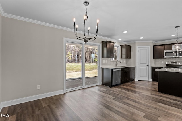 kitchen featuring appliances with stainless steel finishes, hanging light fixtures, dark brown cabinets, and backsplash