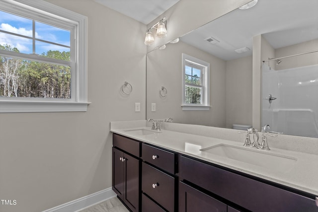 bathroom featuring vanity, a shower, and toilet