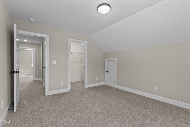 additional living space with vaulted ceiling and light carpet