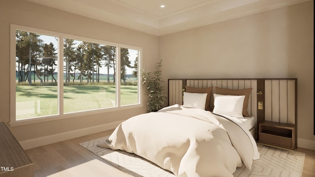 bedroom featuring a tray ceiling and light wood-type flooring