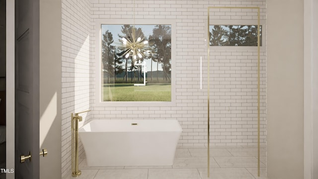 bathroom with tile patterned flooring, tile walls, and a tub to relax in