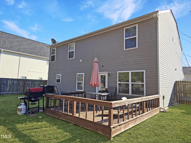 rear view of property with a fenced backyard, a wooden deck, and a yard