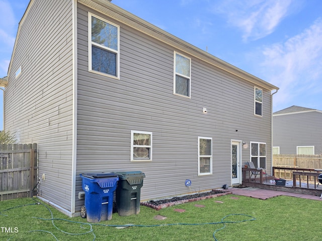 rear view of property with a patio area, a yard, and fence