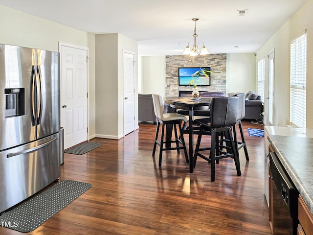 dining area with dark wood-style flooring, visible vents, baseboards, and an inviting chandelier