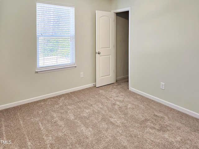 carpeted empty room with baseboards