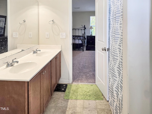 full bathroom with double vanity, tile patterned floors, a sink, and connected bathroom