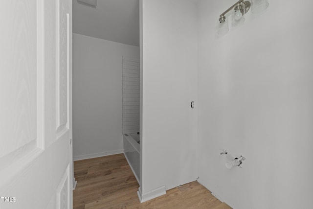 bathroom featuring wood-type flooring and a tub