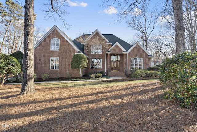 traditional home featuring brick siding and a front lawn