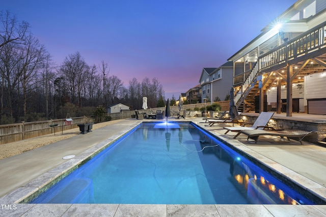 pool at dusk featuring a patio