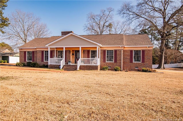 ranch-style house featuring a front yard and covered porch