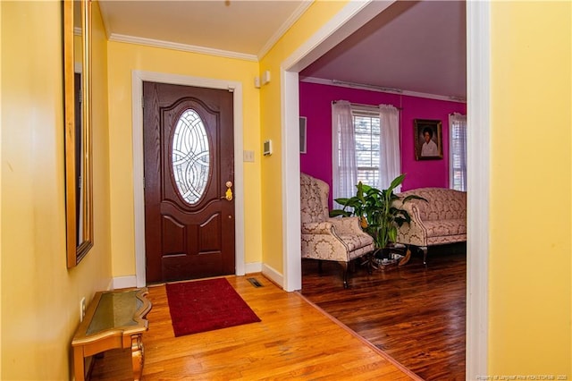 foyer with crown molding and hardwood / wood-style flooring