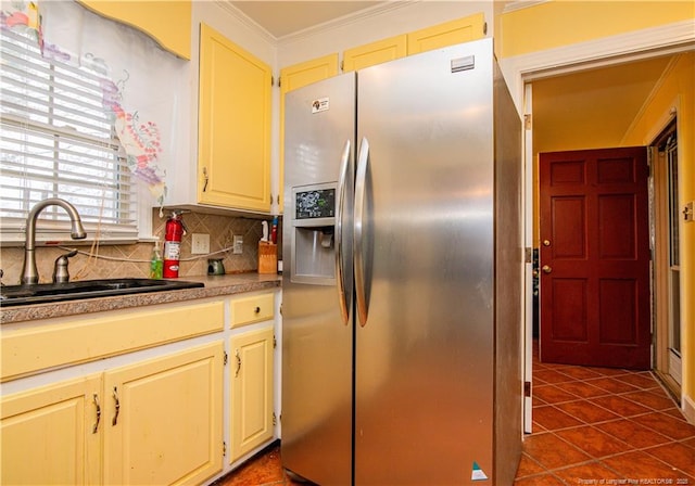 kitchen featuring sink, stainless steel fridge, dark tile patterned floors, tasteful backsplash, and ornamental molding