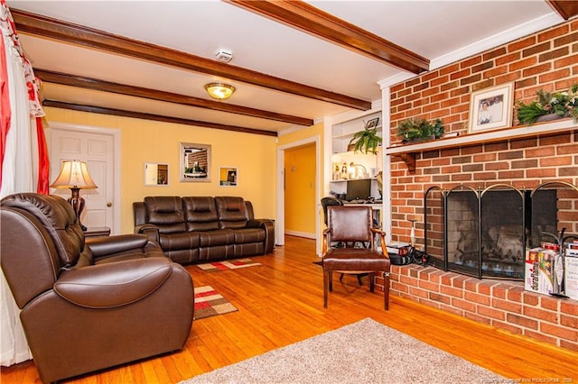 living room with beamed ceiling, wood-type flooring, and a fireplace