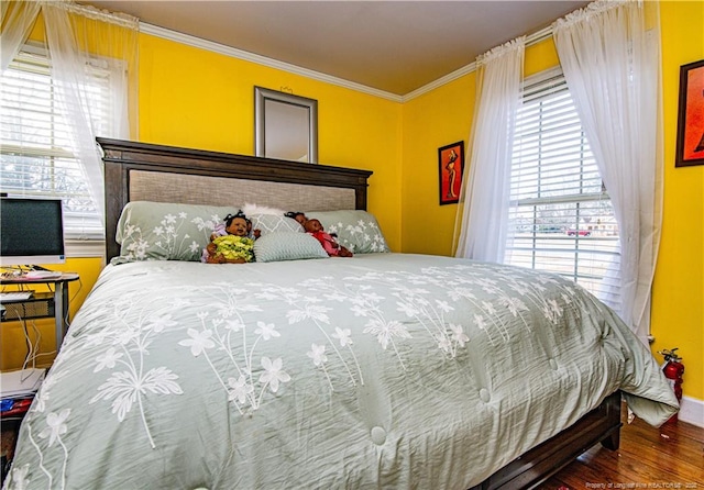 bedroom with crown molding and wood-type flooring