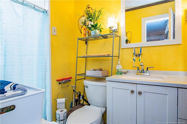 bathroom with crown molding, vanity, and toilet