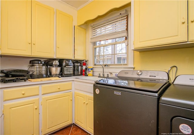 laundry room with crown molding, separate washer and dryer, sink, and dark tile patterned flooring