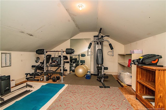 exercise room with lofted ceiling and hardwood / wood-style flooring