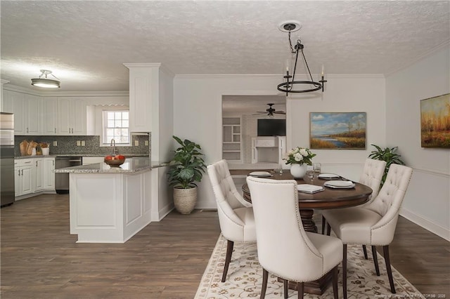 dining space featuring ornamental molding, dark hardwood / wood-style flooring, sink, and a textured ceiling