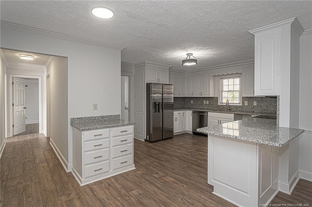 kitchen featuring sink, appliances with stainless steel finishes, light stone countertops, white cabinets, and kitchen peninsula