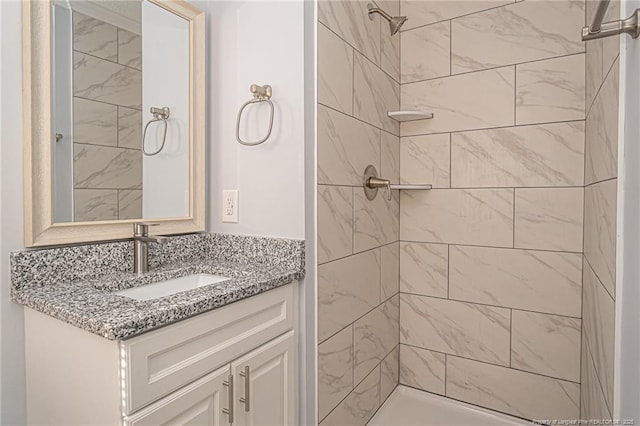 bathroom with vanity and a tile shower