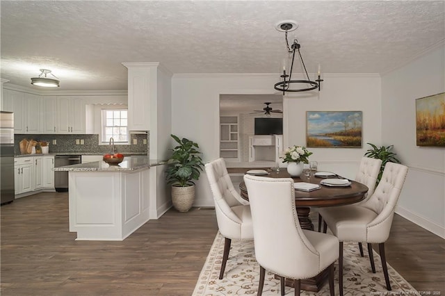 6628 Camden Rd, Fayetteville, NC 28306 - dining space with ceiling fan, a textured ceiling, dark wood-style flooring, a chandelier, and crown molding