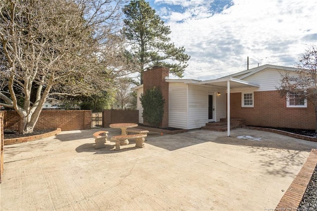 6628 Camden Rd, Fayetteville, NC 28306 - view of front facade with brick siding, a chimney, a patio area, and a gate