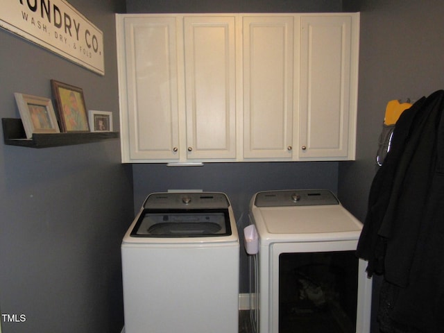 laundry room featuring cabinets and washer and clothes dryer