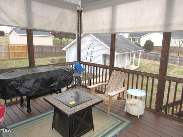 wooden terrace featuring a yard and an outdoor fire pit