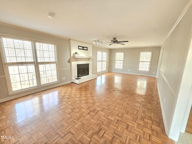 unfurnished living room featuring crown molding, light parquet floors, and ceiling fan