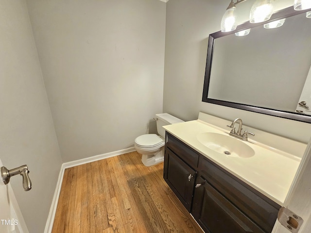 bathroom with vanity, wood-type flooring, and toilet