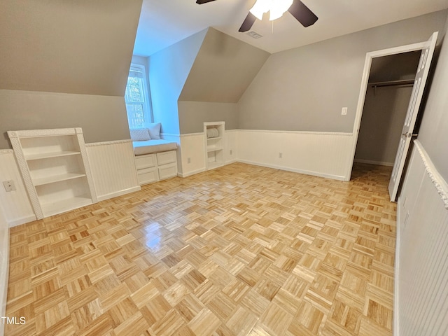 additional living space with ceiling fan, light parquet flooring, and vaulted ceiling