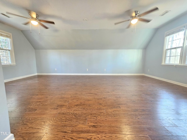 bonus room with ceiling fan, dark hardwood / wood-style floors, and a wealth of natural light