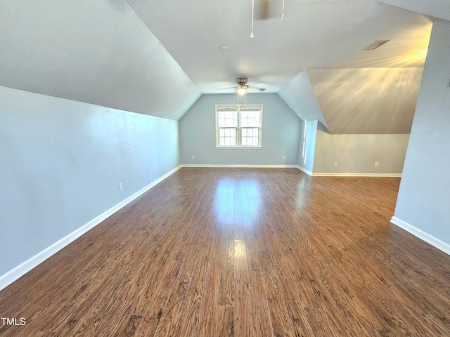 additional living space with ceiling fan, dark hardwood / wood-style floors, and vaulted ceiling