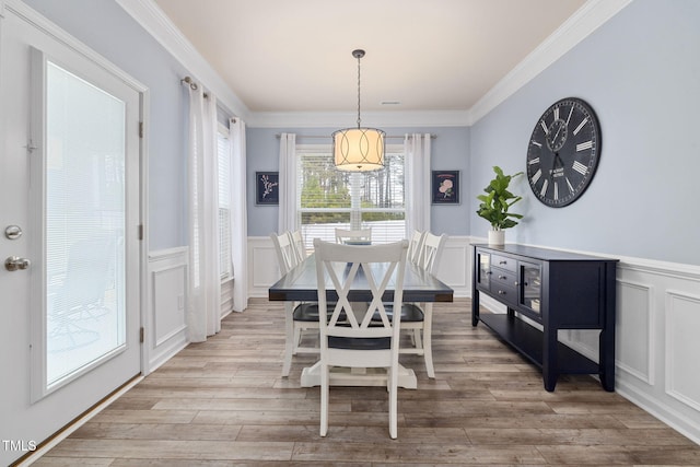 dining space featuring crown molding and light hardwood / wood-style floors