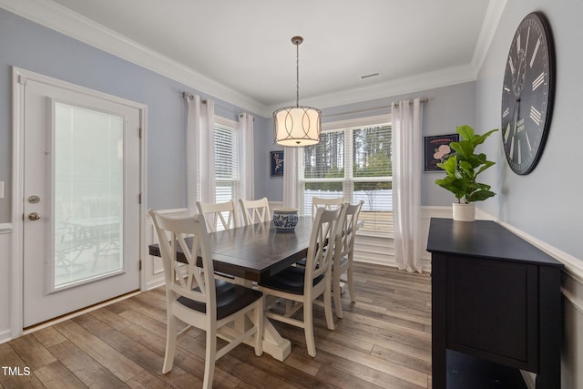 dining space featuring hardwood / wood-style flooring and ornamental molding