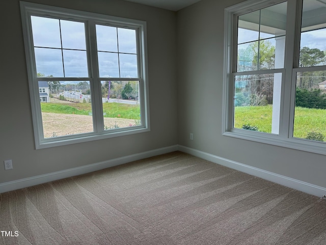 carpeted spare room featuring plenty of natural light