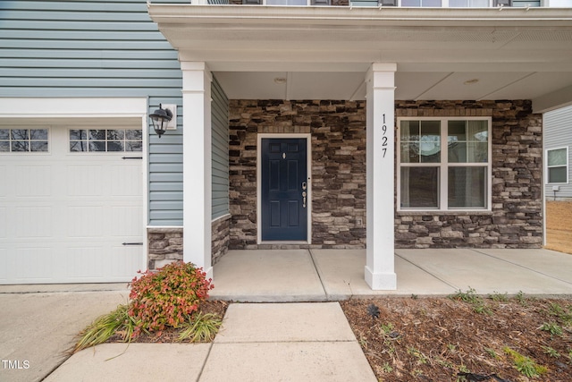 view of exterior entry featuring a garage and a porch