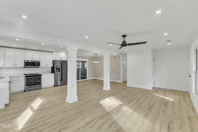 kitchen featuring appliances with stainless steel finishes, decorative columns, white cabinetry, ceiling fan, and light wood-type flooring