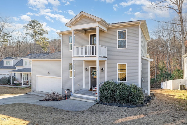 view of front of home with a garage, a balcony, and cooling unit