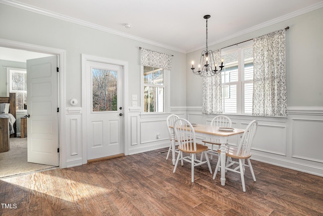 dining area featuring crown molding, a notable chandelier, and dark hardwood / wood-style flooring