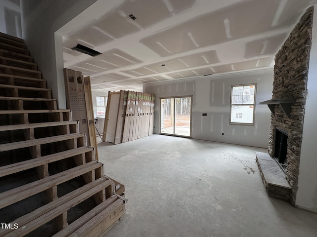 unfurnished living room featuring stairs and a fireplace