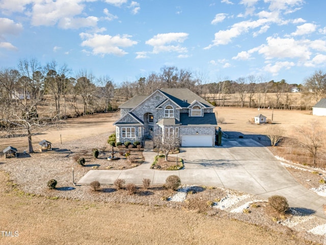 view of front of property featuring a garage and a rural view