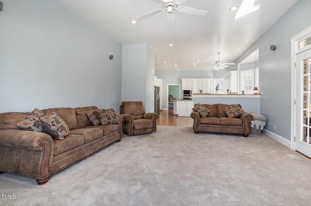 living room featuring light carpet and ceiling fan