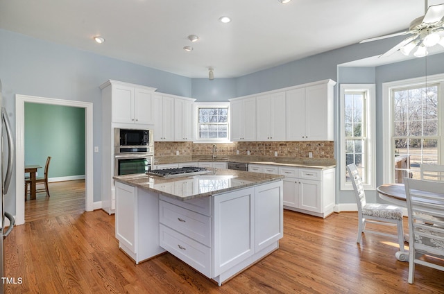 kitchen featuring stainless steel appliances, a kitchen island, and white cabinets