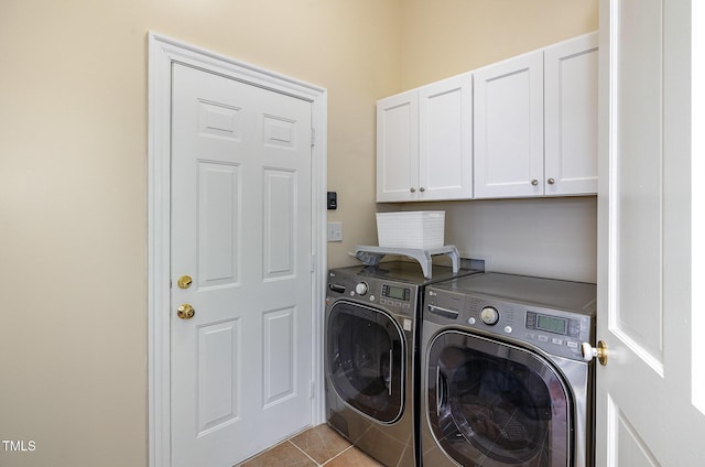 clothes washing area with separate washer and dryer, light tile patterned floors, and cabinets